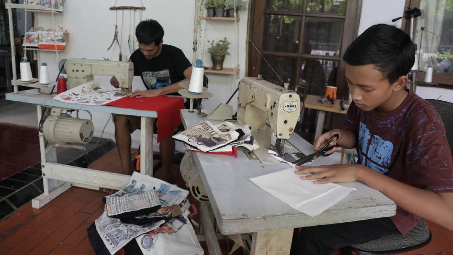 Pengrajin saat menjahit tas kantongan berbahan kanvas organik/katun yang diproduksi menjadi sovenir khas Jakarta di Workshop AIU Craft, Jakarta Timur. (CNBC Indonesia/Muhammad Sabki)
