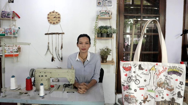 Pengrajin saat menjahit tas kantongan berbahan kanvas organik/katun yang diproduksi menjadi sovenir khas Jakarta di Workshop AIU Craft, Jakarta Timur. (CNBC Indonesia/Muhammad Sabki)