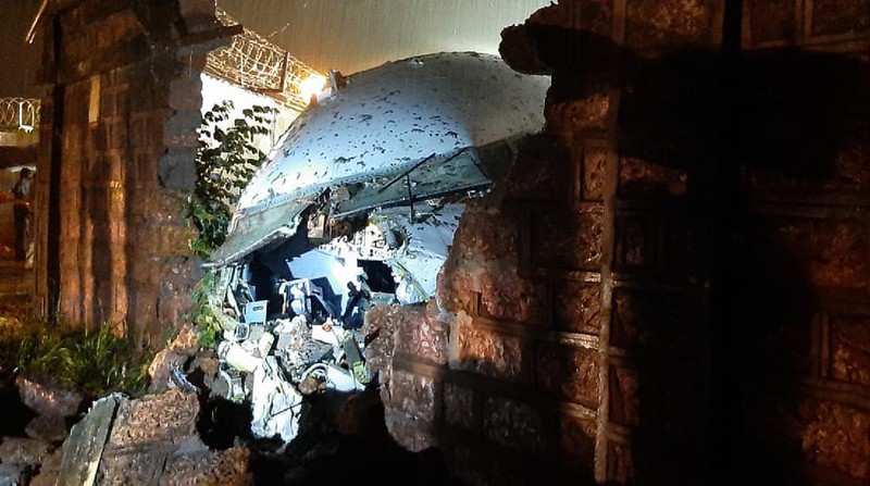 The Air India Express flight that skidded off a runway while landing at the airport in Kozhikode, Kerala state, India, Saturday, Aug. 8, 2020. The special evacuation flight bringing people home to India who had been trapped abroad because of the coronavirus skidded off the runway and split in two while landing in heavy rain killing more than a dozen people and injuring dozens more. (AP Photo/C.K.Thanseer)