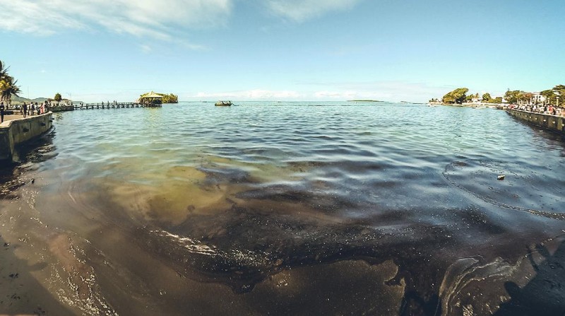 This photo taken and provided by Eric Villars shows oil leaking from the MV Wakashio, a bulk carrier ship that recently ran aground off the southeast coast of Mauritius, Friday, Aug. 7, 2020. Anxious residents of the Indian Ocean island nation of Mauritius are stuffing fabric sacks with sugar cane leaves to create makeshift oil spill barriers as tons of fuel leak from a grounded ship. The government has declared an environmental emergency and France says it is sending help from its nearby Reunion island. (Eric Villars via AP)