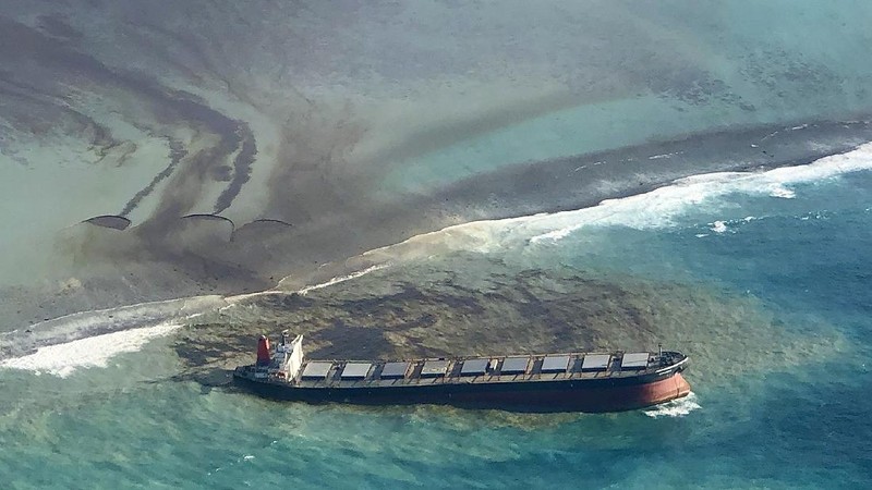 This photo taken and provided by Eric Villars shows oil leaking from the MV Wakashio, a bulk carrier ship that recently ran aground off the southeast coast of Mauritius, Friday, Aug. 7, 2020. Anxious residents of the Indian Ocean island nation of Mauritius are stuffing fabric sacks with sugar cane leaves to create makeshift oil spill barriers as tons of fuel leak from a grounded ship. The government has declared an environmental emergency and France says it is sending help from its nearby Reunion island. (Eric Villars via AP)