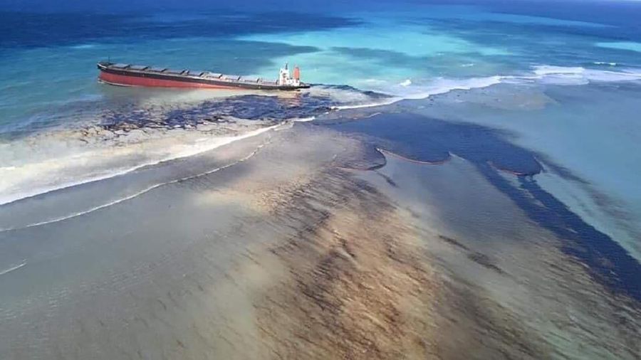 This photo taken and provided by Eric Villars shows oil leaking from the MV Wakashio, a bulk carrier ship that recently ran aground off the southeast coast of Mauritius, Friday, Aug. 7, 2020. Anxious residents of the Indian Ocean island nation of Mauritius are stuffing fabric sacks with sugar cane leaves to create makeshift oil spill barriers as tons of fuel leak from a grounded ship. The government has declared an environmental emergency and France says it is sending help from its nearby Reunion island. (Eric Villars via AP)