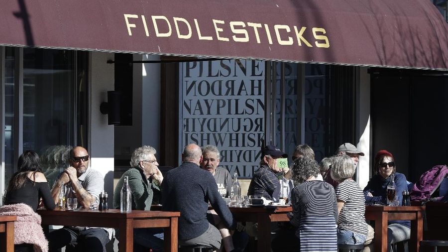 Customers at a cafe enjoy lunch in the sunshine in Christchurch, New Zealand, Sunday, Aug. 9, 2020. New Zealand marked a 100 days of being free from the coronavirus in its communities Sunday, Aug. 9, with just a handful of infections continuing to be picked up at the border where people are quarantined. (AP Photo/Mark Baker)