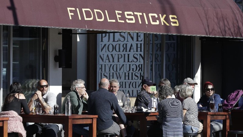 Customers at a cafe enjoy lunch in the sunshine in Christchurch, New Zealand, Sunday, Aug. 9, 2020. New Zealand marked a 100 days of being free from the coronavirus in its communities Sunday, Aug. 9, with just a handful of infections continuing to be picked up at the border where people are quarantined. (AP Photo/Mark Baker)