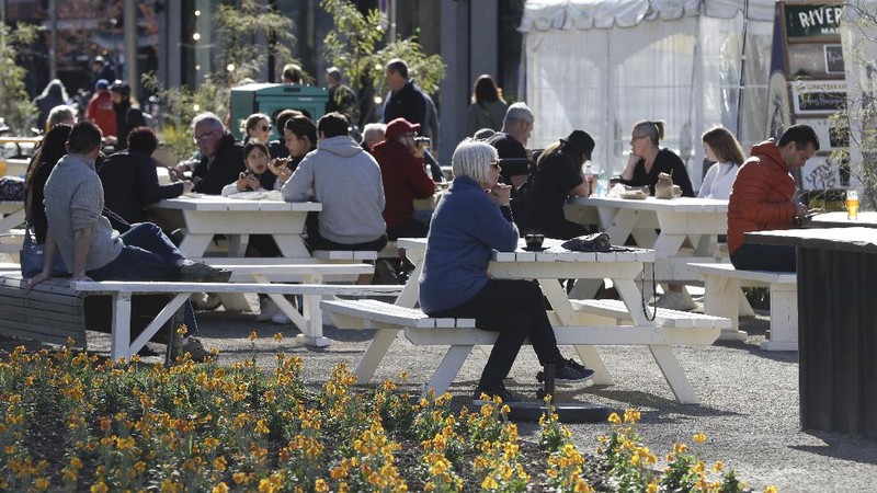 Customers at a cafe enjoy lunch in the sunshine in Christchurch, New Zealand, Sunday, Aug. 9, 2020. New Zealand marked a 100 days of being free from the coronavirus in its communities Sunday, Aug. 9, with just a handful of infections continuing to be picked up at the border where people are quarantined. (AP Photo/Mark Baker)