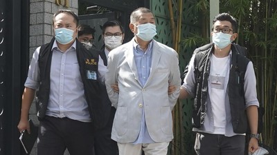 Hong Kong media tycoon Jimmy Lai, center, who founded local newspaper Apple Daily, is arrested by police officers at his home in Hong Kong, Monday, Aug. 10, 2020. Hong Kong police arrested Lai and raided the publisher's headquarters Monday in the highest-profile use yet of the new national security law Beijing imposed on the city after protests last year. (AP Photo)