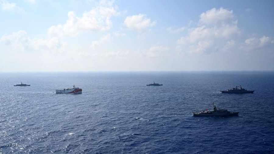 In this photo provided by the Turkish Defense Ministry, Turkey's research vessel, Oruc Reis, in red and white, is surrounded by Turkish navy vessels as it was heading in the west of Antalya on the Mediterranean, Turkey, Monday, Aug 10, 2020. Tension remains high between Greece and Turkey, whose warships are in the eastern Mediterranean where Turkey has sent a research vessel to carry out seismic research for energy resources in an area Greece says is on its continental shelf. (Turkish Defense Ministry via AP, Pool)