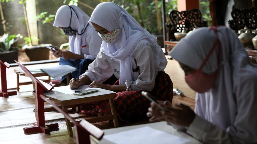 Sejumlah siswa belajar menggunakan fasilitas wifi gratis di Sanggar Suluk Nusantara di Wilayah Perumahan Depok Mulya 1, Depok, Jawa Barat, Selasa (11/8/2020). Sri Wiwoho pemilik sanggar budaya sekaligus warga yang memprakarsai wifi gratis ini mengungkap Fasilitas wifi itu disediakan sebagai bentuk kepedulian atas kesulitan biaya untuk kebutuhan belajar daring 
