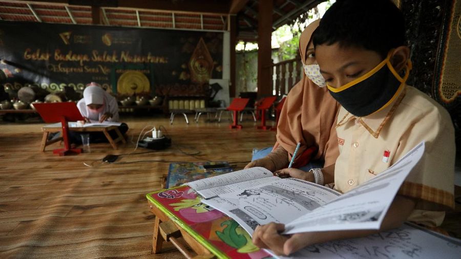 Sejumlah siswa belajar menggunakan fasilitas wifi gratis di Sanggar Suluk Nusantara di Wilayah Perumahan Depok Mulya 1, Depok, Jawa Barat, Selasa (11/8/2020). Sri Wiwoho pemilik sanggar budaya sekaligus warga yang memprakarsai wifi gratis ini mengungkap Fasilitas wifi itu disediakan sebagai bentuk kepedulian atas kesulitan biaya untuk kebutuhan belajar daring 
