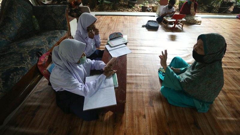 Sejumlah siswa belajar menggunakan fasilitas wifi gratis di Sanggar Suluk Nusantara di Wilayah Perumahan Depok Mulya 1, Depok, Jawa Barat, Selasa (11/8/2020). Sri Wiwoho pemilik sanggar budaya sekaligus warga yang memprakarsai wifi gratis ini mengungkap Fasilitas wifi itu disediakan sebagai bentuk kepedulian atas kesulitan biaya untuk kebutuhan belajar daring 