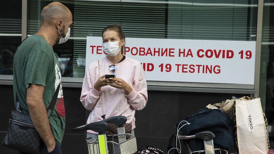 A couple queue at a COVID-19 test center at Vnukovo airport outside Moscow, Russia, Friday, Aug. 7, 2020. Authorities in Russia say they are about to approve a COVID-19 vaccine, with mass vaccinations planned as early as October 2020, using shots that are yet to complete clinical trials. But scientists worldwide are sounding the alarm that the headlong rush could backfire and point to ethical issues that undermine confidence in the Russian studies.  (AP Photo/Pavel Golovkin)