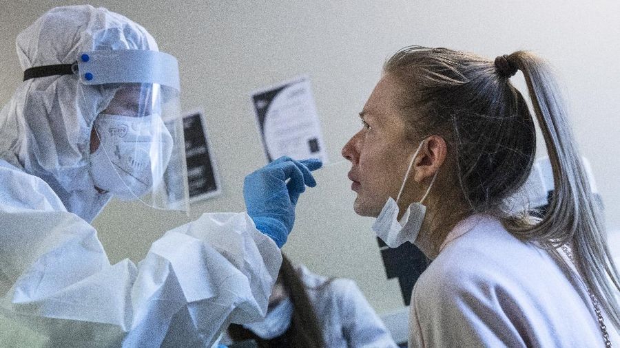 A medical worker performs a COVID-19 test at a test center at Vnukovo airport outside Moscow, Russia, Friday, Aug. 7, 2020. Authorities in Russia say they are about to approve a COVID-19 vaccine, with mass vaccinations planned as early as October 2020, using shots that are yet to complete clinical trials. But scientists worldwide are sounding the alarm that the headlong rush could backfire and point to ethical issues that undermine confidence in the Russian studies.  (AP Photo/Pavel Golovkin)