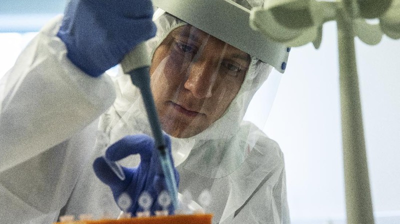 Petugas medis dengan alat pelindung mengambil darah para sukarelawan yang berpartisipasi dalam uji coba vaksin virus corona di Rumah Sakit Utama Militer Budenko di luar Moskow, Rusia.  (Russian Defense Ministry Press Service via AP)
