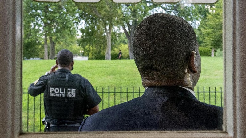 A U.S. Secret Service police officer stands on the roof of the the White House, Monday, Aug. 10, 2020, in Washington, as a news conference by President Donald Trump was paused. (AP Photo/Andrew Harnik)