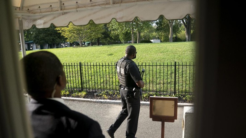 A U.S. Secret Service police officer stands on the roof of the the White House, Monday, Aug. 10, 2020, in Washington, as a news conference by President Donald Trump was paused. (AP Photo/Andrew Harnik)