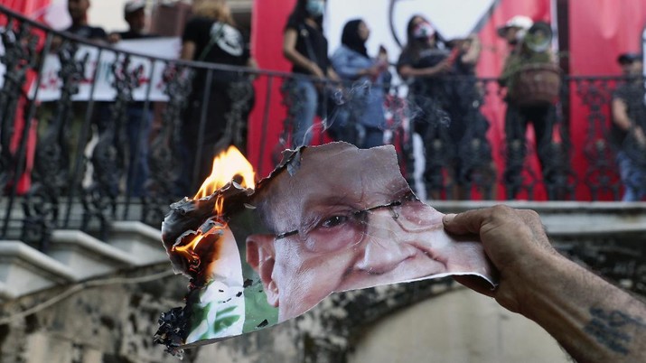 Seorang pengunjuk rasa anti-pemerintah membakar foto Presiden Lebanon Michel Aoun di dalam kementerian luar negeri Lebanon di Beirut, Lebanon, Sabtu, 8 Agustus 2020. (AP/Bilal Hussein) Seorang pengunjuk rasa anti-pemerintah membakar foto Presiden Lebanon Michel Aoun di dalam kementerian luar negeri Lebanon di Beirut, Lebanon, Sabtu, 8 Agustus 2020. (AP/Bilal Hussein)