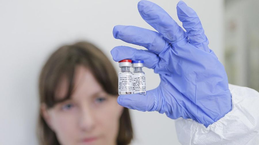 In this handout photo taken on Thursday, Aug. 6, 2020, and provided by Russian Direct Investment Fund, an employee shows a new vaccine at the Nikolai Gamaleya National Center of Epidemiology and Microbiology in Moscow, Russia. Russia on Tuesday, Aug. 11 became the first country to approve a coronavirus vaccine for use in tens of thousands of its citizens despite international skepticism about injections that have not completed clinical trials and were studied in only dozens of people for less than two months. (Alexander Zemlianichenko Jr/ Russian Direct Investment Fund via AP)