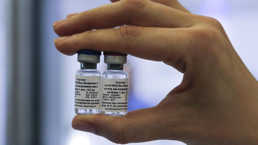 In this handout photo taken on Thursday, Aug. 6, 2020, and provided by Russian Direct Investment Fund, an employee shows a new vaccine at the Nikolai Gamaleya National Center of Epidemiology and Microbiology in Moscow, Russia. Russia on Tuesday, Aug. 11 became the first country to approve a coronavirus vaccine for use in tens of thousands of its citizens despite international skepticism about injections that have not completed clinical trials and were studied in only dozens of people for less than two months. (Alexander Zemlianichenko Jr/ Russian Direct Investment Fund via AP)