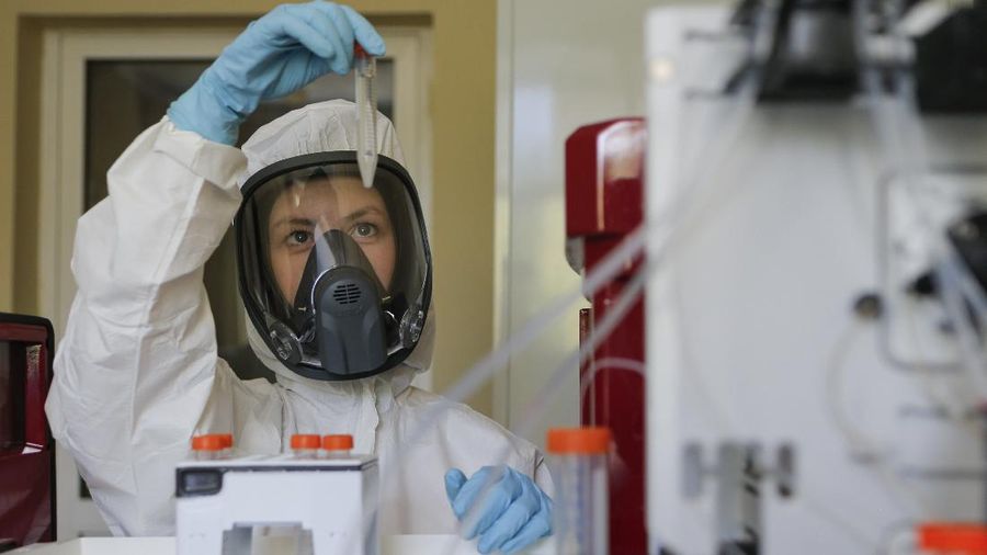 In this handout photo taken on Thursday, Aug. 6, 2020, and provided by Russian Direct Investment Fund, an employee shows a new vaccine at the Nikolai Gamaleya National Center of Epidemiology and Microbiology in Moscow, Russia. Russia on Tuesday, Aug. 11 became the first country to approve a coronavirus vaccine for use in tens of thousands of its citizens despite international skepticism about injections that have not completed clinical trials and were studied in only dozens of people for less than two months. (Alexander Zemlianichenko Jr/ Russian Direct Investment Fund via AP)