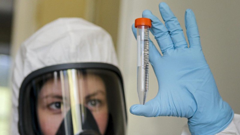 In this handout photo taken on Thursday, Aug. 6, 2020, and provided by Russian Direct Investment Fund, an employee shows a new vaccine at the Nikolai Gamaleya National Center of Epidemiology and Microbiology in Moscow, Russia. Russia on Tuesday, Aug. 11 became the first country to approve a coronavirus vaccine for use in tens of thousands of its citizens despite international skepticism about injections that have not completed clinical trials and were studied in only dozens of people for less than two months. (Alexander Zemlianichenko Jr/ Russian Direct Investment Fund via AP)