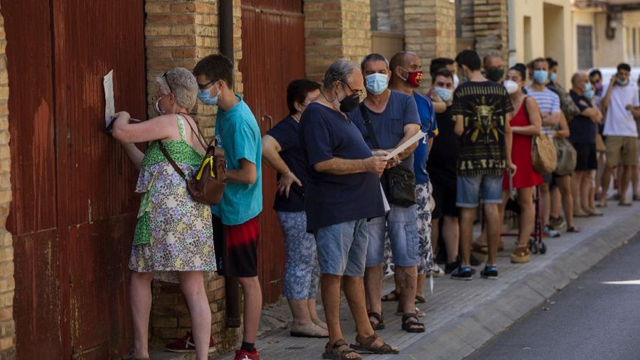 Spanish NGO Open Arms volunteer,  Julia Martin, 38, plays with 4-month old Biel, as his father takes a COVID-19 PCR test, at Vilafranca del Penedes in the Barcelona province, Spain, Tuesday, Aug. 11, 2020. Spain is facing another surge in coronavirus infections not even two months after beating back the first wave. (AP Photo/Emilio Morenatti)