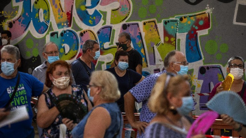 Spanish NGO Open Arms volunteer,  Julia Martin, 38, plays with 4-month old Biel, as his father takes a COVID-19 PCR test, at Vilafranca del Penedes in the Barcelona province, Spain, Tuesday, Aug. 11, 2020. Spain is facing another surge in coronavirus infections not even two months after beating back the first wave. (AP Photo/Emilio Morenatti)