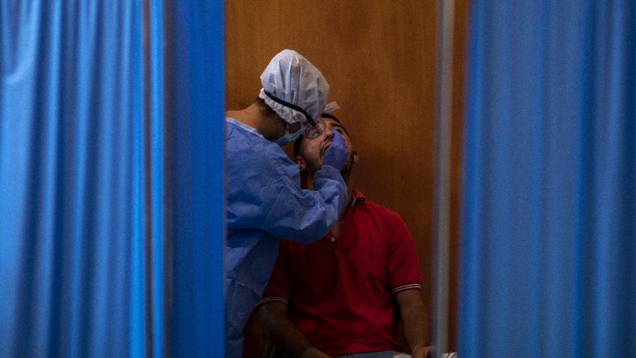 Spanish NGO Open Arms volunteer,  Julia Martin, 38, plays with 4-month old Biel, as his father takes a COVID-19 PCR test, at Vilafranca del Penedes in the Barcelona province, Spain, Tuesday, Aug. 11, 2020. Spain is facing another surge in coronavirus infections not even two months after beating back the first wave. (AP Photo/Emilio Morenatti)