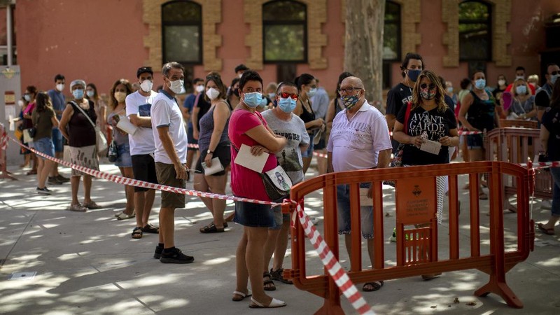 Spanish NGO Open Arms volunteer,  Julia Martin, 38, plays with 4-month old Biel, as his father takes a COVID-19 PCR test, at Vilafranca del Penedes in the Barcelona province, Spain, Tuesday, Aug. 11, 2020. Spain is facing another surge in coronavirus infections not even two months after beating back the first wave. (AP Photo/Emilio Morenatti)