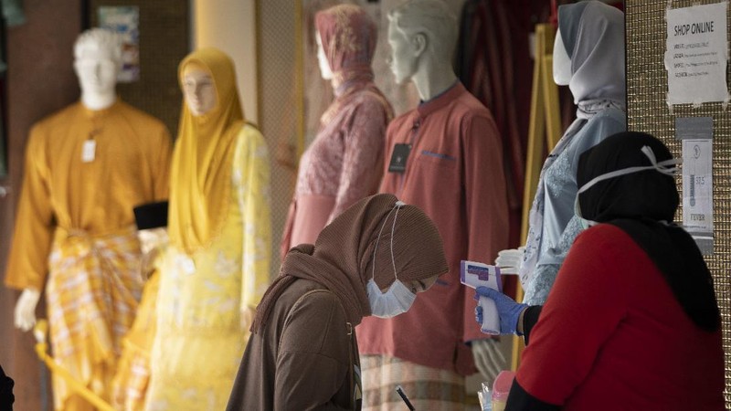A retail shop staff prepare to reopen in Kuala Lumpur, Malaysia, on Monday, May 4, 2020. Many business sectors reopened Monday in some parts of Malaysia since a partial virus lockdown began March 18. The easing of restrictions, days before the lockdown was due to end May 12, came as Prime Minister Muhyiddin Yassin's government sought to balance between curbing the virus and reviving the hard-hit economy.(AP Photo/Vincent Thian)