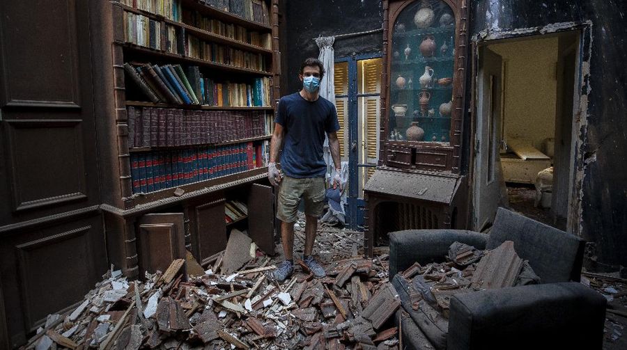 Said Al Assaad, 24, poses for a photograph inside his grandfather's destroyed villa after Tuesday's explosion in the seaport of Beirut, Lebanon, Thursday, Aug. 6, 2020. The gigantic explosion in Beirut on Tuesday tore through homes, blowing off doors and windows, toppling cupboards, and sent flying books, shelves, lamps and everything else. Within a few tragic seconds, more than a quarter of a million people of the Lebanese capital's residents were left with homes unfit to live in. Around 6,200 buildings are estimated to be damaged. (AP Photo/Hassan Ammar)