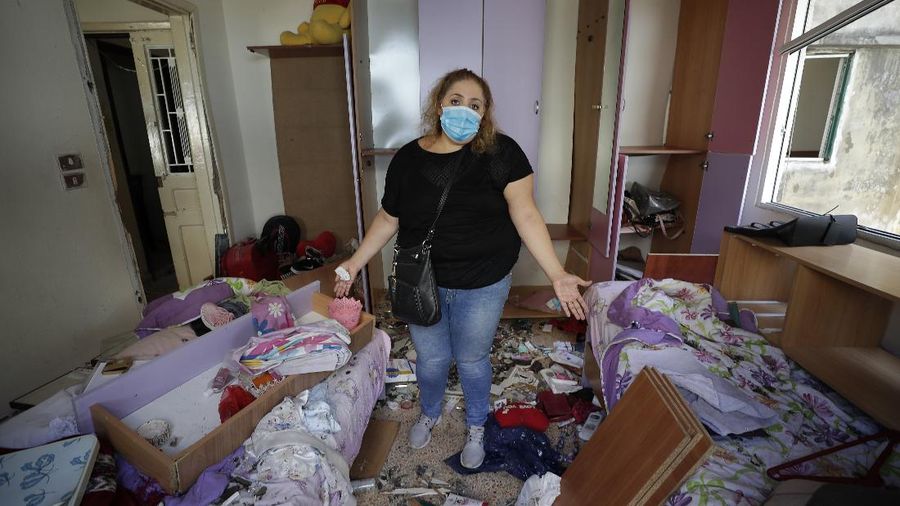 Said Al Assaad, 24, poses for a photograph inside his grandfather's destroyed villa after Tuesday's explosion in the seaport of Beirut, Lebanon, Thursday, Aug. 6, 2020. The gigantic explosion in Beirut on Tuesday tore through homes, blowing off doors and windows, toppling cupboards, and sent flying books, shelves, lamps and everything else. Within a few tragic seconds, more than a quarter of a million people of the Lebanese capital's residents were left with homes unfit to live in. Around 6,200 buildings are estimated to be damaged. (AP Photo/Hassan Ammar)