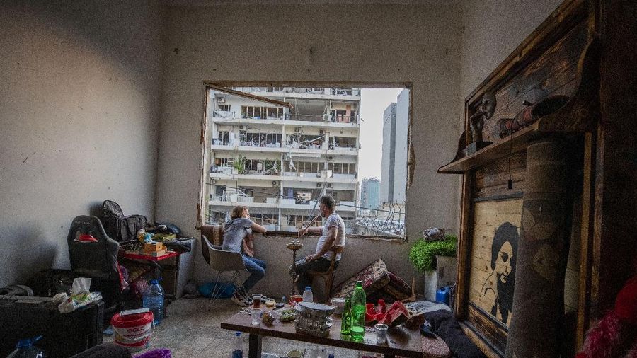 Said Al Assaad, 24, poses for a photograph inside his grandfather's destroyed villa after Tuesday's explosion in the seaport of Beirut, Lebanon, Thursday, Aug. 6, 2020. The gigantic explosion in Beirut on Tuesday tore through homes, blowing off doors and windows, toppling cupboards, and sent flying books, shelves, lamps and everything else. Within a few tragic seconds, more than a quarter of a million people of the Lebanese capital's residents were left with homes unfit to live in. Around 6,200 buildings are estimated to be damaged. (AP Photo/Hassan Ammar)