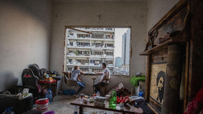 Said Al Assaad, 24, poses for a photograph inside his grandfather's destroyed villa after Tuesday's explosion in the seaport of Beirut, Lebanon, Thursday, Aug. 6, 2020. The gigantic explosion in Beirut on Tuesday tore through homes, blowing off doors and windows, toppling cupboards, and sent flying books, shelves, lamps and everything else. Within a few tragic seconds, more than a quarter of a million people of the Lebanese capital's residents were left with homes unfit to live in. Around 6,200 buildings are estimated to be damaged. (AP Photo/Hassan Ammar)