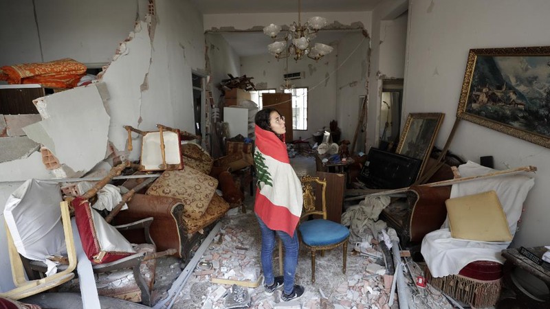 Said Al Assaad, 24, poses for a photograph inside his grandfather's destroyed villa after Tuesday's explosion in the seaport of Beirut, Lebanon, Thursday, Aug. 6, 2020. The gigantic explosion in Beirut on Tuesday tore through homes, blowing off doors and windows, toppling cupboards, and sent flying books, shelves, lamps and everything else. Within a few tragic seconds, more than a quarter of a million people of the Lebanese capital's residents were left with homes unfit to live in. Around 6,200 buildings are estimated to be damaged. (AP Photo/Hassan Ammar)