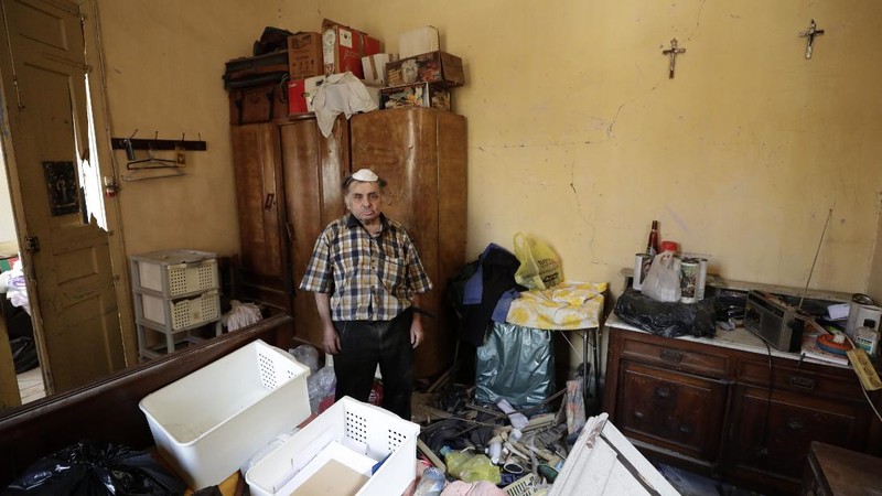 Said Al Assaad, 24, poses for a photograph inside his grandfather's destroyed villa after Tuesday's explosion in the seaport of Beirut, Lebanon, Thursday, Aug. 6, 2020. The gigantic explosion in Beirut on Tuesday tore through homes, blowing off doors and windows, toppling cupboards, and sent flying books, shelves, lamps and everything else. Within a few tragic seconds, more than a quarter of a million people of the Lebanese capital's residents were left with homes unfit to live in. Around 6,200 buildings are estimated to be damaged. (AP Photo/Hassan Ammar)