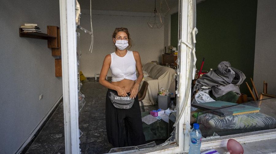 Said Al Assaad, 24, poses for a photograph inside his grandfather's destroyed villa after Tuesday's explosion in the seaport of Beirut, Lebanon, Thursday, Aug. 6, 2020. The gigantic explosion in Beirut on Tuesday tore through homes, blowing off doors and windows, toppling cupboards, and sent flying books, shelves, lamps and everything else. Within a few tragic seconds, more than a quarter of a million people of the Lebanese capital's residents were left with homes unfit to live in. Around 6,200 buildings are estimated to be damaged. (AP Photo/Hassan Ammar)
