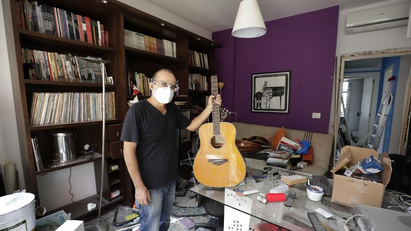 Said Al Assaad, 24, poses for a photograph inside his grandfather's destroyed villa after Tuesday's explosion in the seaport of Beirut, Lebanon, Thursday, Aug. 6, 2020. The gigantic explosion in Beirut on Tuesday tore through homes, blowing off doors and windows, toppling cupboards, and sent flying books, shelves, lamps and everything else. Within a few tragic seconds, more than a quarter of a million people of the Lebanese capital's residents were left with homes unfit to live in. Around 6,200 buildings are estimated to be damaged. (AP Photo/Hassan Ammar)