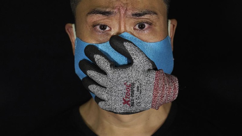 This combination of photos shows Edmond Kok, a Hong Kong theater costume designer and actor, wearing a variety of face masks he made to protect against the coronavirus in Hong Kong Thursday, Aug. 6, 2020. With little theater work because of the coronavirus pandemic, Kok has found a way to turn the now ubiquitous face mask into a creative opportunity. Since February, he has created more than 170 face masks inspired both by the pandemic and Hong Kong’s political problems - not for actual use but as pieces of art. (AP Photo/Vincent Yu)