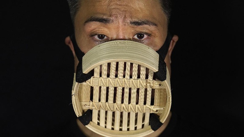 This combination of photos shows Edmond Kok, a Hong Kong theater costume designer and actor, wearing a variety of face masks he made to protect against the coronavirus in Hong Kong Thursday, Aug. 6, 2020. With little theater work because of the coronavirus pandemic, Kok has found a way to turn the now ubiquitous face mask into a creative opportunity. Since February, he has created more than 170 face masks inspired both by the pandemic and Hong Kong’s political problems - not for actual use but as pieces of art. (AP Photo/Vincent Yu)