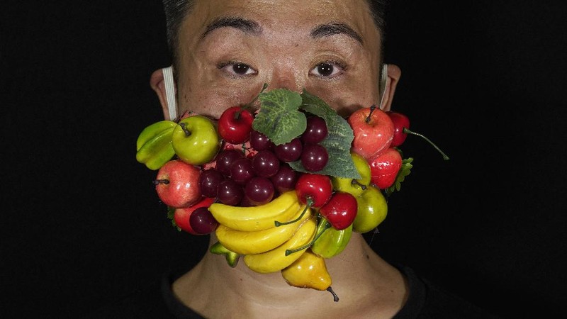 This combination of photos shows Edmond Kok, a Hong Kong theater costume designer and actor, wearing a variety of face masks he made to protect against the coronavirus in Hong Kong Thursday, Aug. 6, 2020. With little theater work because of the coronavirus pandemic, Kok has found a way to turn the now ubiquitous face mask into a creative opportunity. Since February, he has created more than 170 face masks inspired both by the pandemic and Hong Kong’s political problems - not for actual use but as pieces of art. (AP Photo/Vincent Yu)