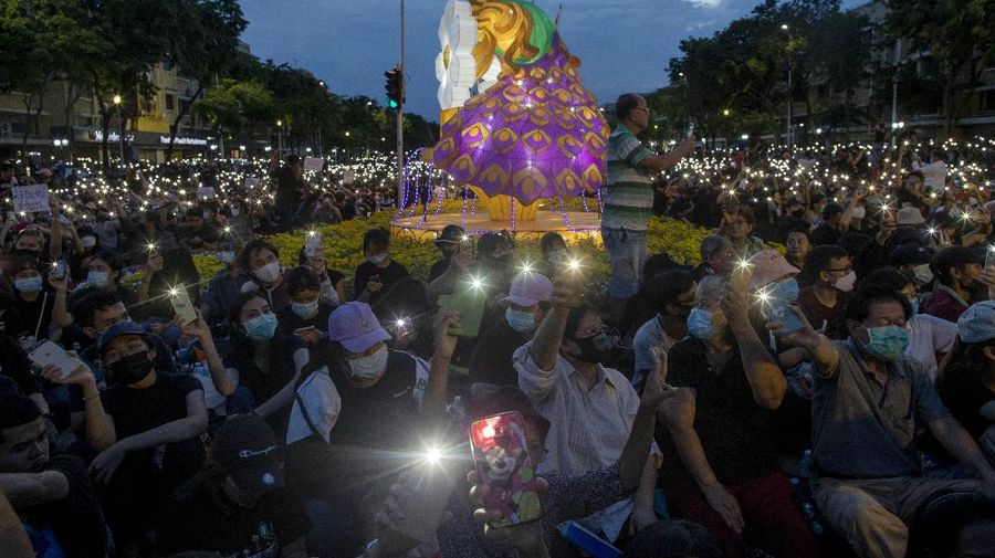 Pro-democracy activities gestures during a protest at Democracy Monument in Bangkok, Thailand, Sunday, Aug, 16, 2020. Protesters have stepped up pressure on the government demanding to dissolve the parliament, hold new elections, amend the constitution and end intimidation of the government's opponents. (AP Photo/Gemunu Amarasinghe)