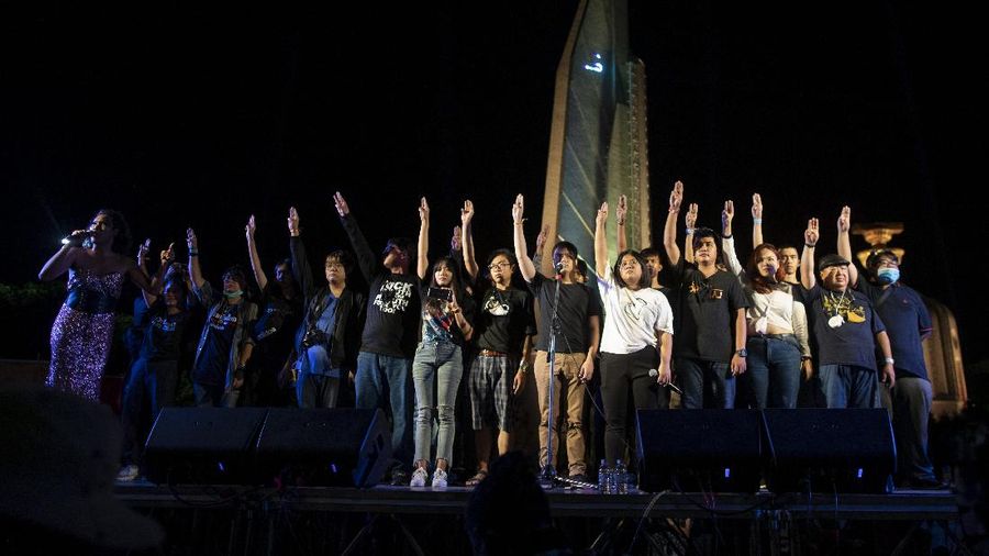 Pro-democracy activities gestures during a protest at Democracy Monument in Bangkok, Thailand, Sunday, Aug, 16, 2020. Protesters have stepped up pressure on the government demanding to dissolve the parliament, hold new elections, amend the constitution and end intimidation of the government's opponents. (AP Photo/Gemunu Amarasinghe)