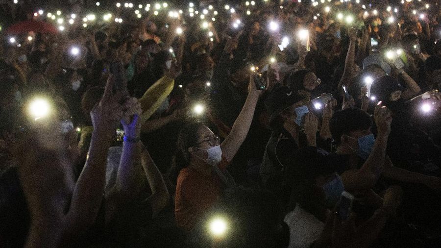 Pro-democracy activities gestures during a protest at Democracy Monument in Bangkok, Thailand, Sunday, Aug, 16, 2020. Protesters have stepped up pressure on the government demanding to dissolve the parliament, hold new elections, amend the constitution and end intimidation of the government's opponents. (AP Photo/Gemunu Amarasinghe)