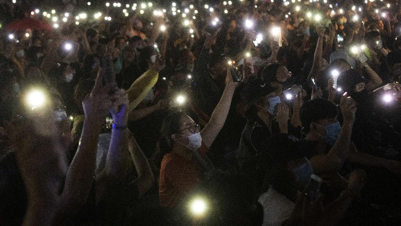 Pro-democracy activities gestures during a protest at Democracy Monument in Bangkok, Thailand, Sunday, Aug, 16, 2020. Protesters have stepped up pressure on the government demanding to dissolve the parliament, hold new elections, amend the constitution and end intimidation of the government's opponents. (AP Photo/Gemunu Amarasinghe)