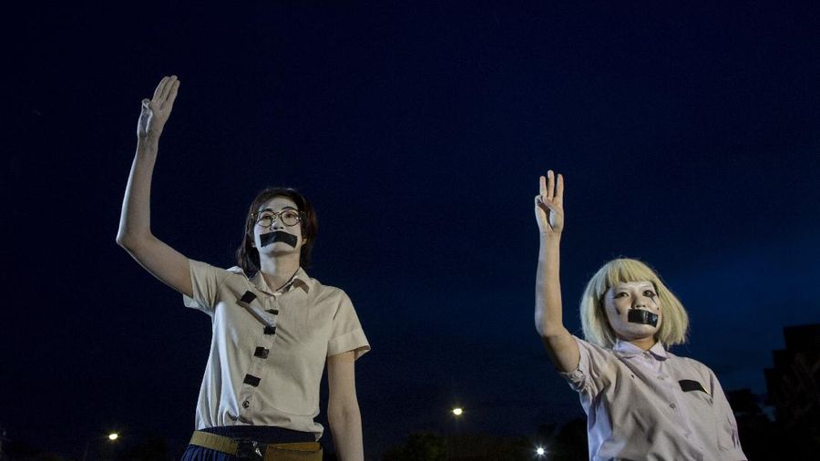 Pro-democracy students raise a three-fingers, symbol of resistance salute during a protest rally at Mahidol University in Nakhan Pathom, Thailand, Tuesday, Aug. 18, 2020.  Student protesters have stepped up pressure on the government with three core demands: holding new elections, amending the constitution and ending the intimidation of critics of the government. (AP Photo/Gemunu Amarasinghe)