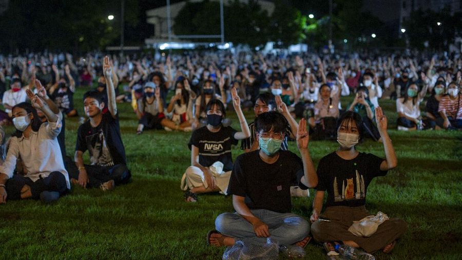 Pro-democracy students raise a three-fingers, symbol of resistance salute during a protest rally at Mahidol University in Nakhan Pathom, Thailand, Tuesday, Aug. 18, 2020.  Student protesters have stepped up pressure on the government with three core demands: holding new elections, amending the constitution and ending the intimidation of critics of the government. (AP Photo/Gemunu Amarasinghe)