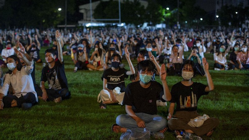 Pro-democracy students raise a three-fingers, symbol of resistance salute during a protest rally at Mahidol University in Nakhan Pathom, Thailand, Tuesday, Aug. 18, 2020.  Student protesters have stepped up pressure on the government with three core demands: holding new elections, amending the constitution and ending the intimidation of critics of the government. (AP Photo/Gemunu Amarasinghe)