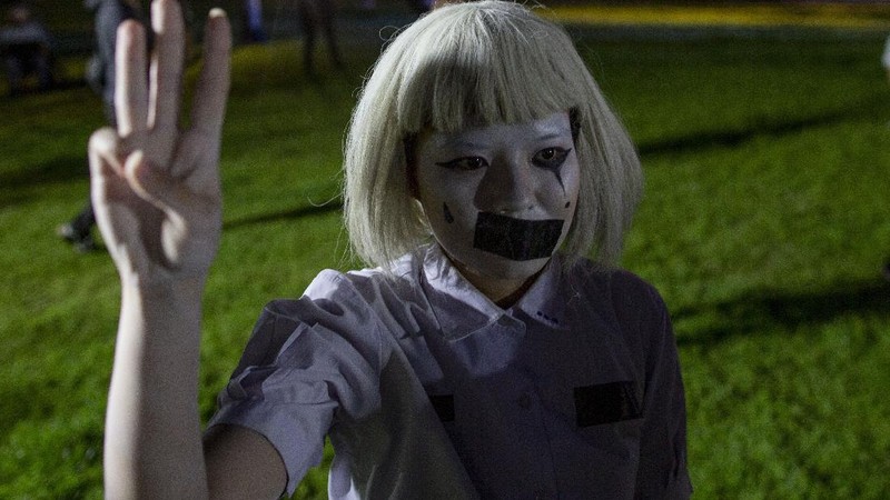 Pro-democracy students raise a three-fingers, symbol of resistance salute during a protest rally at Mahidol University in Nakhan Pathom, Thailand, Tuesday, Aug. 18, 2020.  Student protesters have stepped up pressure on the government with three core demands: holding new elections, amending the constitution and ending the intimidation of critics of the government. (AP Photo/Gemunu Amarasinghe)