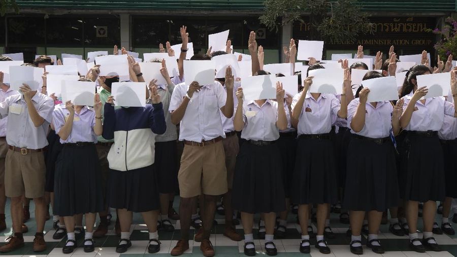 Pro-democracy students raise a three-fingers, symbol of resistance salute during a protest rally at Mahidol University in Nakhan Pathom, Thailand, Tuesday, Aug. 18, 2020.  Student protesters have stepped up pressure on the government with three core demands: holding new elections, amending the constitution and ending the intimidation of critics of the government. (AP Photo/Gemunu Amarasinghe)