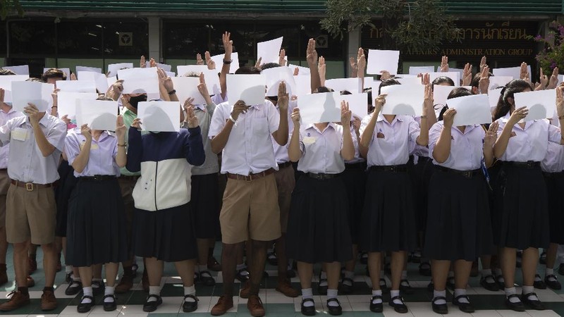 Pro-democracy students raise a three-fingers, symbol of resistance salute during a protest rally at Mahidol University in Nakhan Pathom, Thailand, Tuesday, Aug. 18, 2020.  Student protesters have stepped up pressure on the government with three core demands: holding new elections, amending the constitution and ending the intimidation of critics of the government. (AP Photo/Gemunu Amarasinghe)